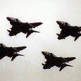 Holding point A four ship formation of military fighter jets was at the holding point of the runway at a civilian airport. Behind them, several civilian airliners and business jets were waiting...