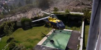 Amazing helicopter pilot taking water from a swimming pool