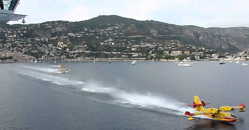 Canadair CL-415 Water Bombers Load Up Next To A Cruise Liner