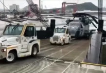 USMC CH-53E slides backward while being loaded onto a transport ship