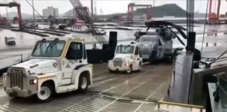 USMC CH-53E slides backward while being loaded onto a transport ship