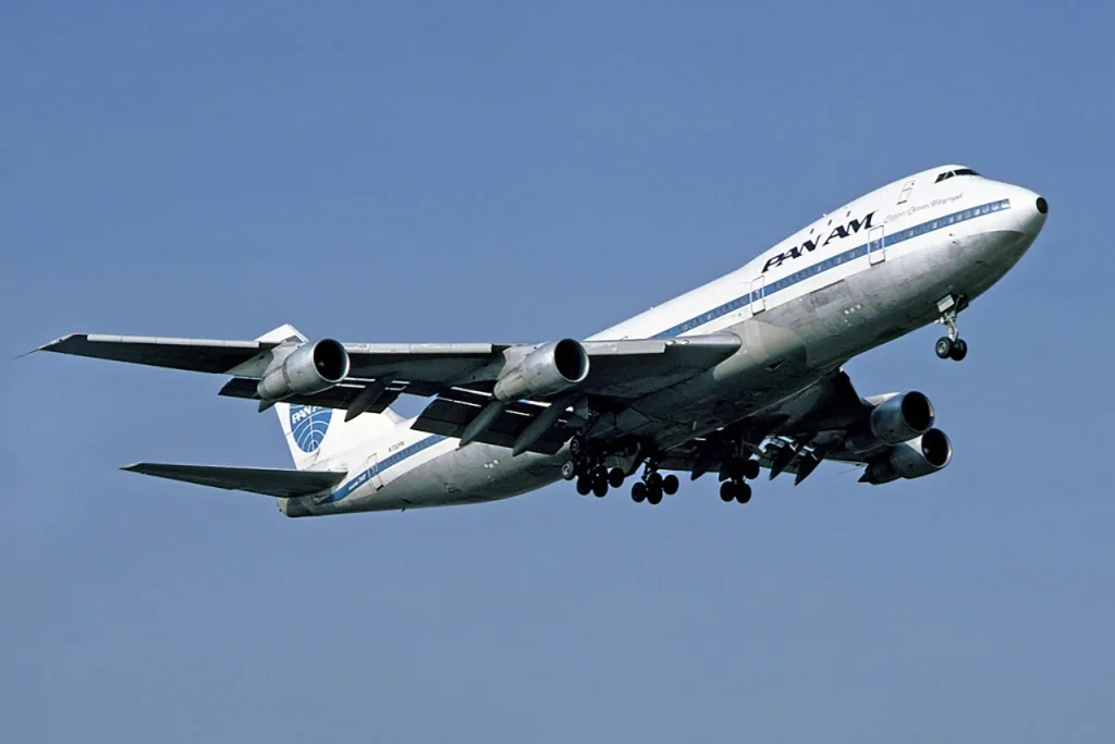 A classic Pan Am Boeing 747, the "Queen of the Skies," taking off against a blue sky, symbolizing its iconic status and revolutionizing commercial air travel.