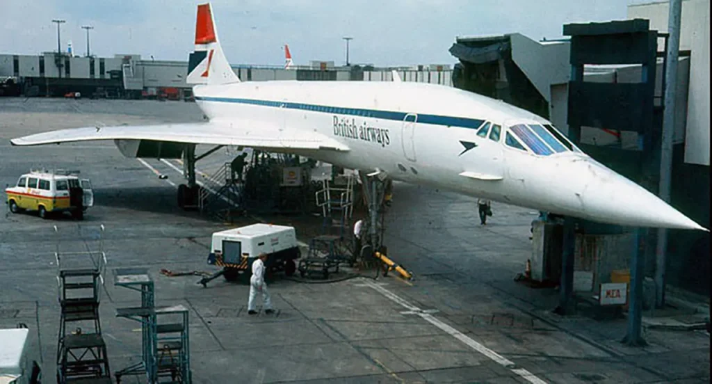 A British Airways Concorde supersonic airliner parked at an airport gate, showcasing its iconic sleek design as one of the most famous aircraft in aviation history.